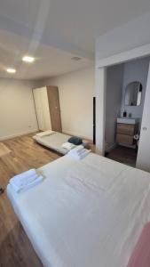 a large white bed in a room with wooden floors at Casa Adrianykenia in San Martín de Laspra