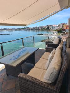 a patio with a table and chairs and a view of the water at Apartamentos Mareventus in Sanxenxo