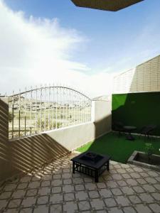 a patio with a table and a bench on a balcony at بيوت عطلات البيت الريفي للضيافه السياحي in Al Namas