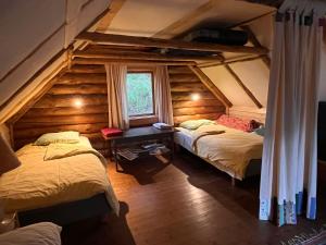 an attic bedroom with two beds and a window at Järvenukka Puhkemaja in Ähijärve