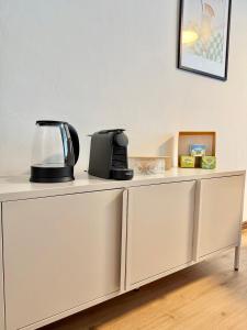 a white cabinet with a coffee maker on top of it at Mountain Nest Apartment in Schottwien +3 photos
