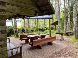 a picnic table with an umbrella and a bench at Järvenukka Puhkemaja in Ähijärve
