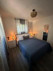a bedroom with a blue bed and a window at The Emerald Cabin in Tobyhanna +21 photos