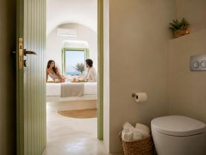 a man and woman sitting in a bed in a bathroom at Mamma Mia Santorini Suites-Volcano -Caldera -Sunset View in Fira +52 photos