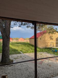 a view from a window of a field with a tree at Sevan Grass and Sky in Sevan