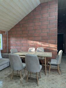 a wooden table with chairs and a brick wall at Sevan Grass and Sky in Sevan