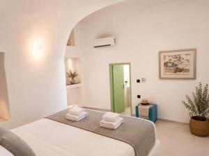 a bedroom with a bed with towels on it at Mamma Mia Santorini Suites-Volcano -Caldera -Sunset View in Fira