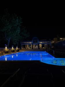 a swimming pool at night with a building in the background at Hotel Miramare in Sottomarina