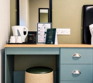 a desk with a stool under a desk with a mirror at Pairc House Hotel in Birmingham