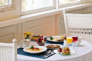 a table with breakfast foods and drinks on it at The Edenton Collection – Captain’s Quarters Inn in Edenton