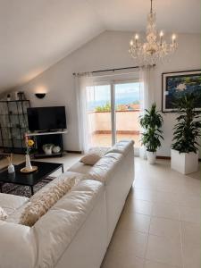 a living room with a white couch and a chandelier at Villa Monaco in Mosciano SantʼAngelo