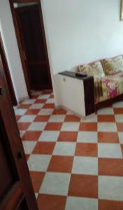 a room with a checkered floor with a bed at Resicence jaouharat zarkaa in M'diq
