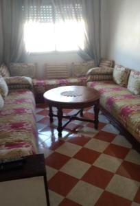 a living room with a couch and a coffee table at Resicence jaouharat zarkaa in M'diq