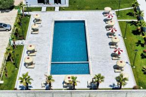 an overhead view of a swimming pool with chairs and umbrellas at Evergreen Laguna Vain-Lezhe in Lezhë