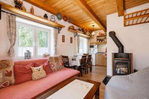 a living room with a pink couch and a fireplace at Norova chata in Závažná Poruba