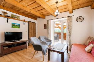 a living room with a couch and a tv at Norova chata in Závažná Poruba