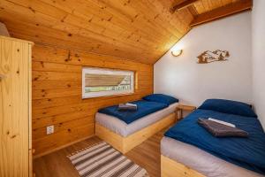 a bedroom with two beds in a log cabin at Norova chata in Závažná Poruba