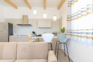 ein Wohnzimmer und eine Küche mit Sofa und Stühlen in der Unterkunft Pasithea House in Lanciano