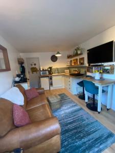 a living room with a couch and a table and a kitchen at The Rest-Well Lodge in Sherborne