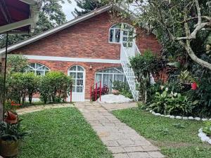 a brick house with a white door and a yard at Touristic House Chalet Luna Verde in Sasaima