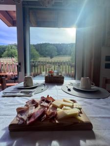 a cutting board with meat and cheese on a table at La Gemma Bed & Breakfast in Montesover