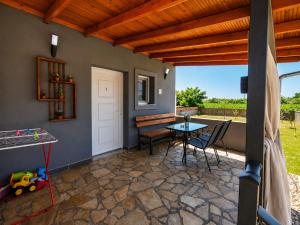 a patio with a table and chairs and a roof at Stella's House Mangana in Mángana
