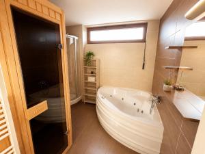 a bathroom with a large tub and a sink at Ski & Sun Wellness Apartments in Liptovský Mikuláš