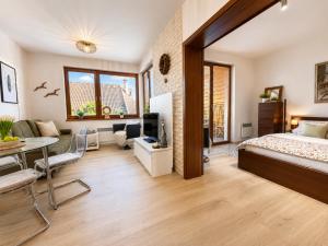 a bedroom with a bed and a living room at Ski & Sun Wellness Apartments in Liptovský Mikuláš