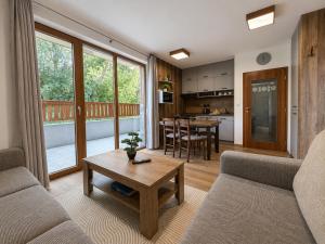 a living room with a couch and a table at Ski & Sun Wellness Apartments in Liptovský Mikuláš +30 photos