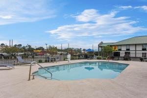 a swimming pool with two chairs and a building at Days Inn by Wyndham Valdosta I-75 in Valdosta
