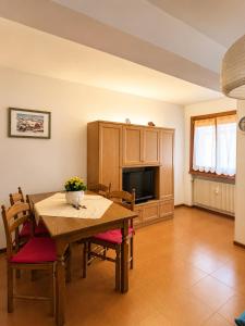 a dining room with a table and a tv at Appartamento Italia in Alleghe