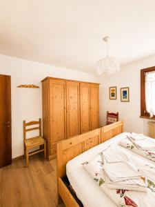 a bedroom with two beds and a chair at Appartamento Italia in Alleghe