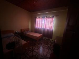 a dark room with a window with a bed and a table at Jean Pierre in La Merced +2 photos