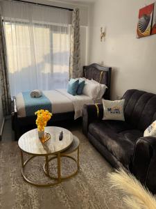 a living room with a couch and a bed at Thesh Home at Tsavo Sunset 2 ,Thindigua Kiambu Road in Kiambu