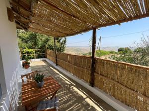 a wooden deck with a table and chairs on it at Dar Serenia Rohuna in Rehouna