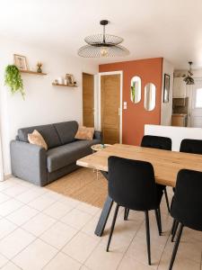 a living room with a table and a couch at La petite maison secrète in Abbeville