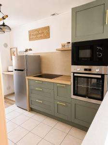 a kitchen with a stove and a refrigerator at La petite maison secrète in Abbeville