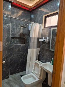 a bathroom with a toilet and a sink at Silid in Legazpi