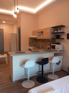 a kitchen with two bar stools and a counter at Modern flat in town center! in Kiaton