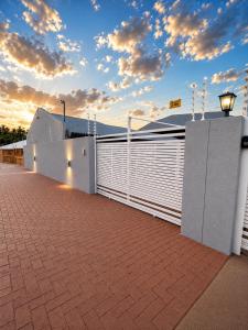 a building with a white fence and a brick sidewalk at CAVE Properties Group in Pionierspark