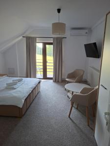a hotel room with a bed and a table and chairs at Casa Nițică in Vaslui