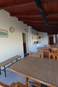 a dining room with a table and chairs and a clock at El Retorno Hostel in Puerto Madryn