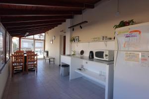 a kitchen with a counter and a dining room at El Retorno Hostel in Puerto Madryn
