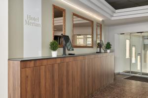 a lobby with a reception desk and a mirror at Riverside Hotel Merian - opening 2026 in Basel