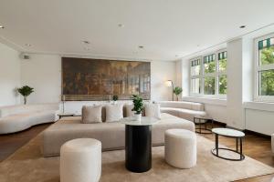 a living room with two couches and a table at Riverside Hotel Merian - opening 2026 in Basel