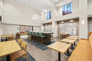 a dining room with tables and chairs and windows at Hampton Inn & Suites Lancaster in Lancaster