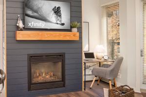 a living room with a fireplace with a tv on the wall at Fraser Crossing 3309 in Winter Park