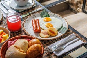a breakfast plate of eggs and bread and a basket of bread at Hotel Monaguillo de Getsemaní in Cartagena de Indias +23 photos