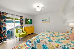 a bedroom with a bed and a yellow chair at Everglades Villa - Sleeps 8 - Walk to Siesta Beach in Siesta Key +21 photos