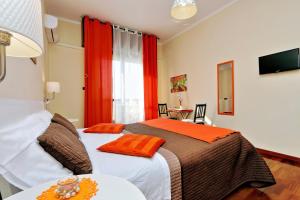 - une chambre dotée d'un lit avec des oreillers orange dans l'établissement Alloggio Re Di Roma, à Rome